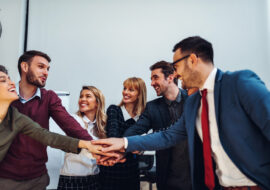 Close up of a group of businesspeople stacking their hands on top of each other