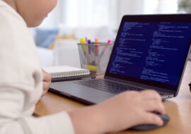 Back rear view of young asian kids boy using computer laptop coding python language programming for big data computer science lesson or tech club in online school remotely learn online school.