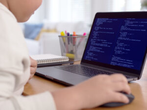 Back rear view of young asian kids boy using computer laptop coding python language programming for big data computer science lesson or tech club in online school remotely learn online school.