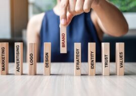 businesswoman-hand-placing-wooden-dominoes-with-te-2022-11-07-22-00-26-utc