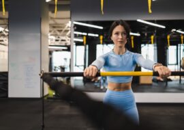 Fitness woman is training with a trx rip trainer in the gym