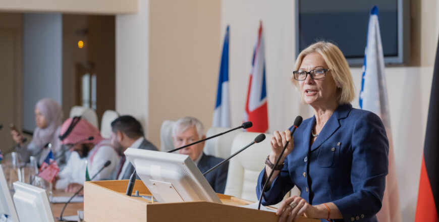 Mature female speaker in elegant suit making report