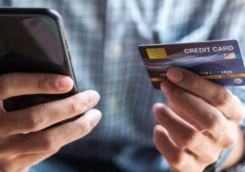 Young casual Business man holding credit card and using touchscreen smartphone for online shopping while making orders in the cafe.business, lifestyle, technology, ecommerce and online payment concept